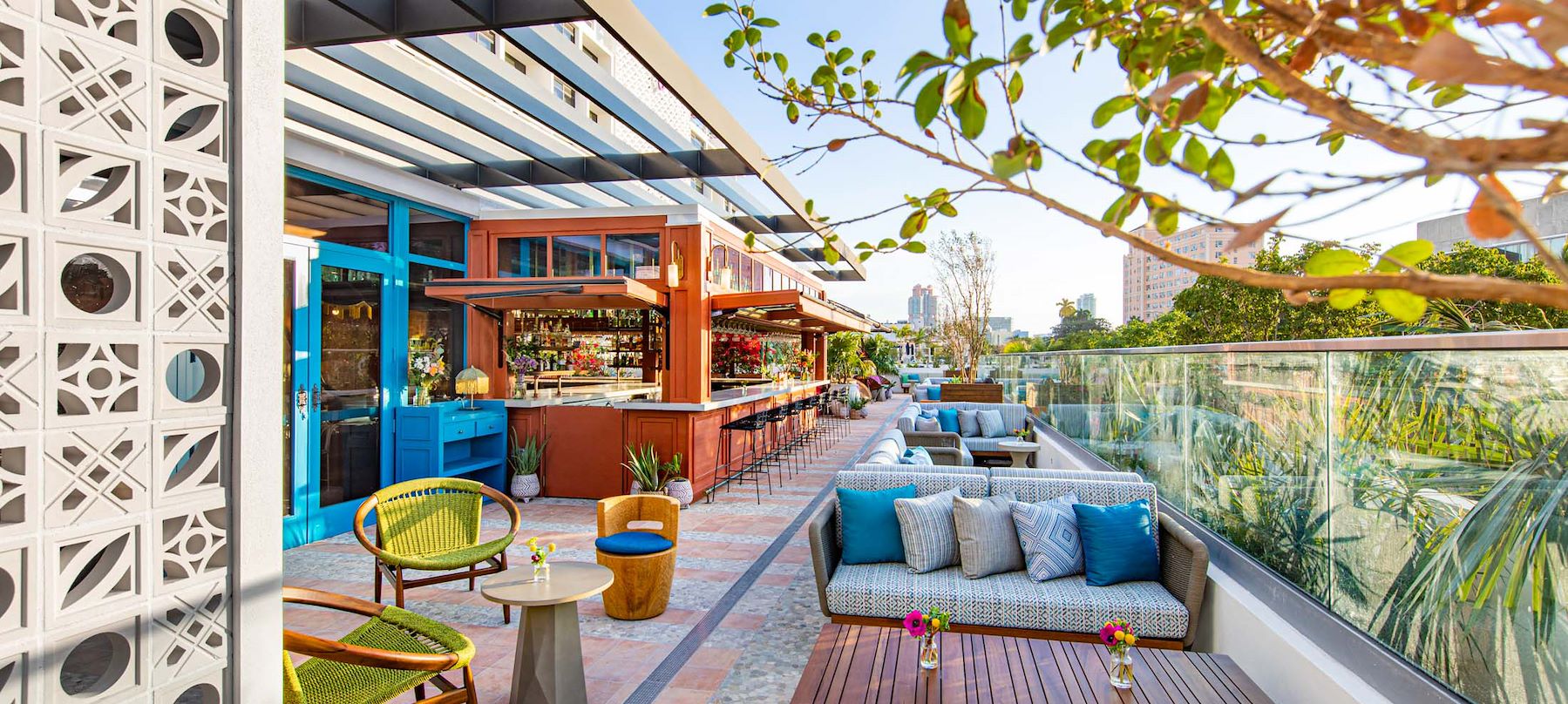 A stylish outdoor bar with seating area and city view