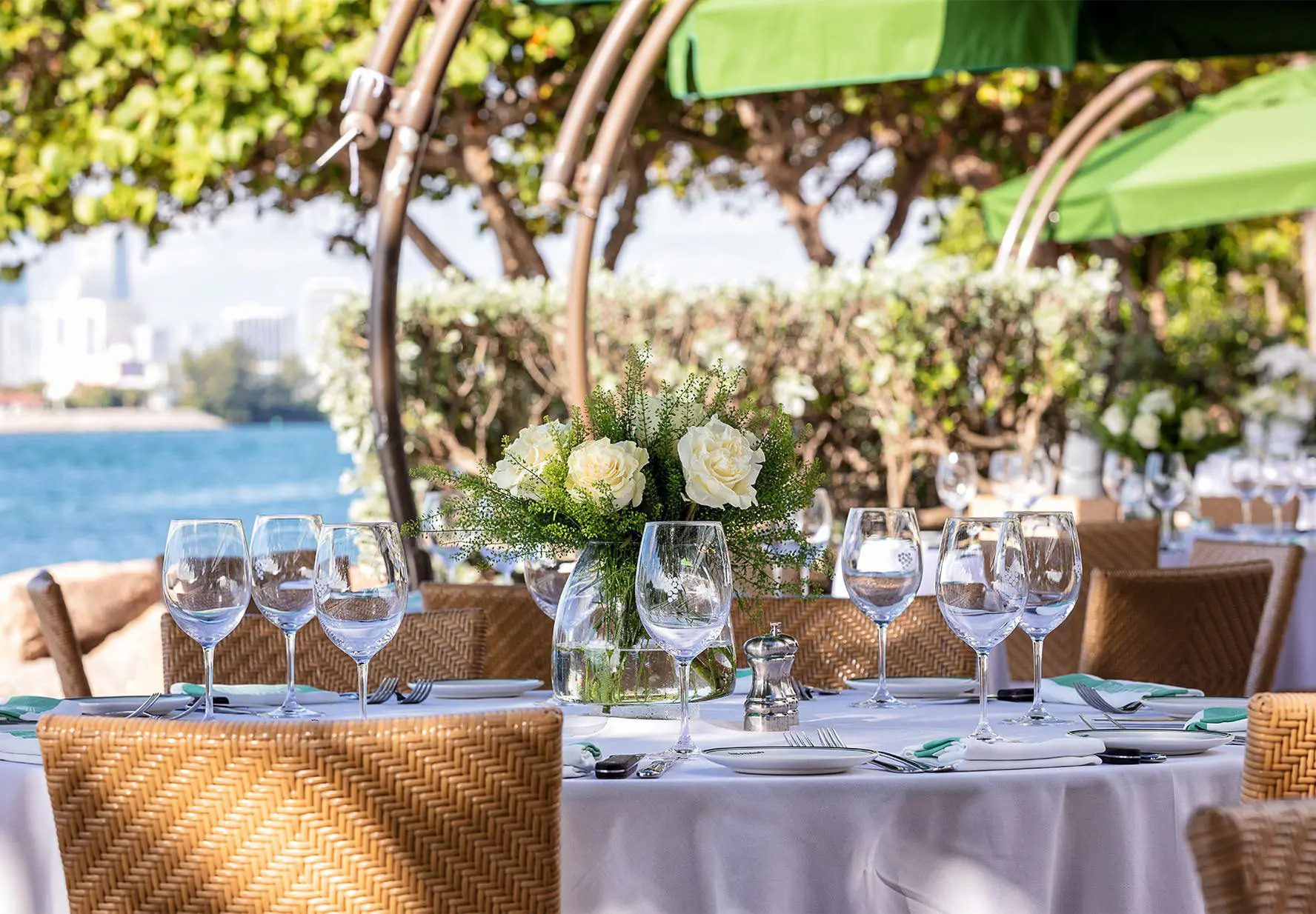 A beautifully set table for dining with a view of the water.